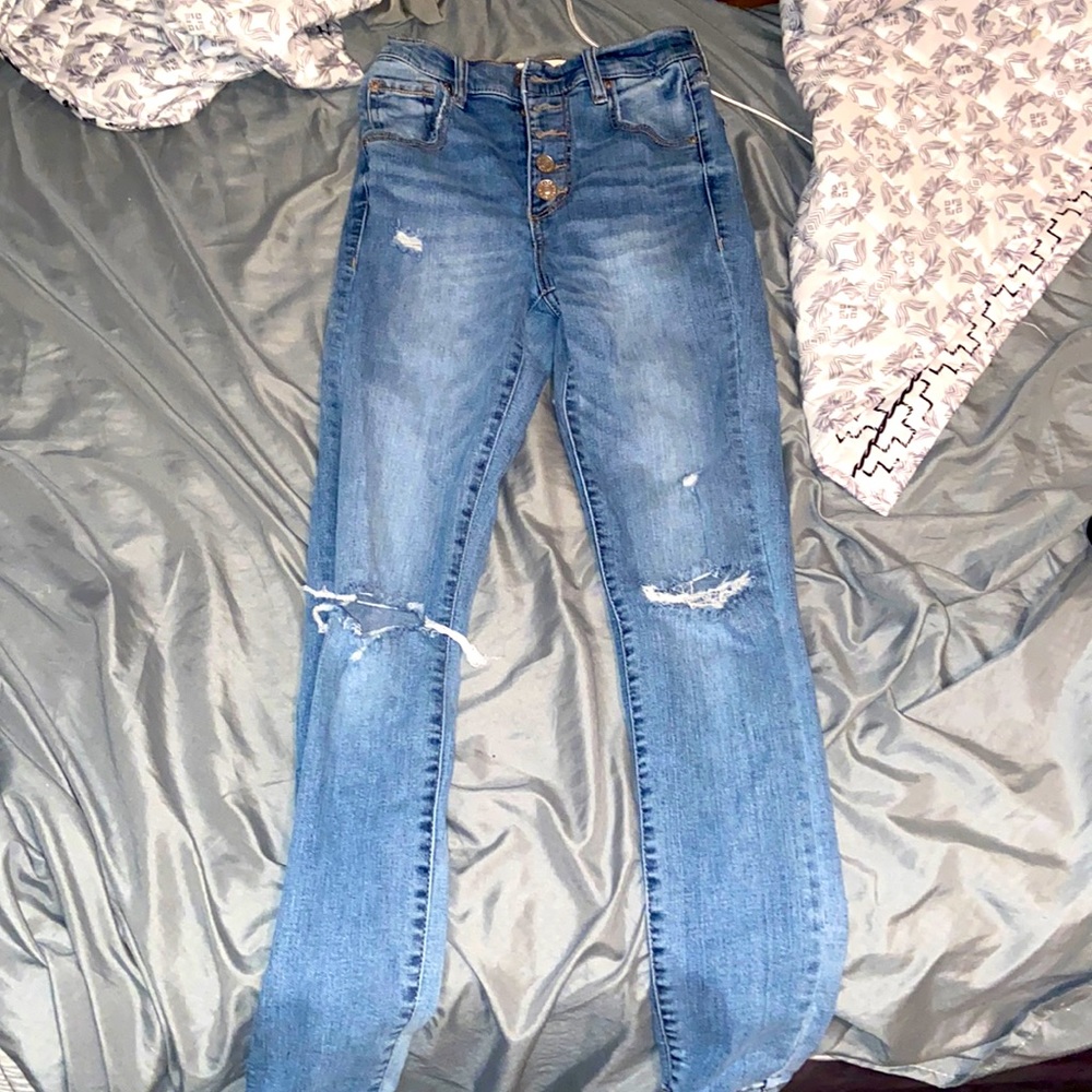 Medium-wash high rise straight leg jeans with rips at the knees